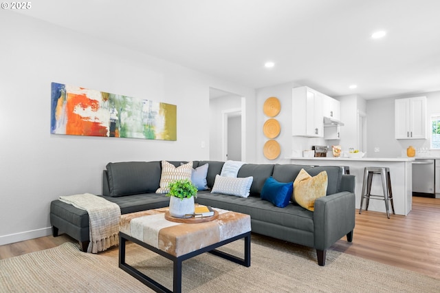 living room featuring light wood finished floors, baseboards, and recessed lighting