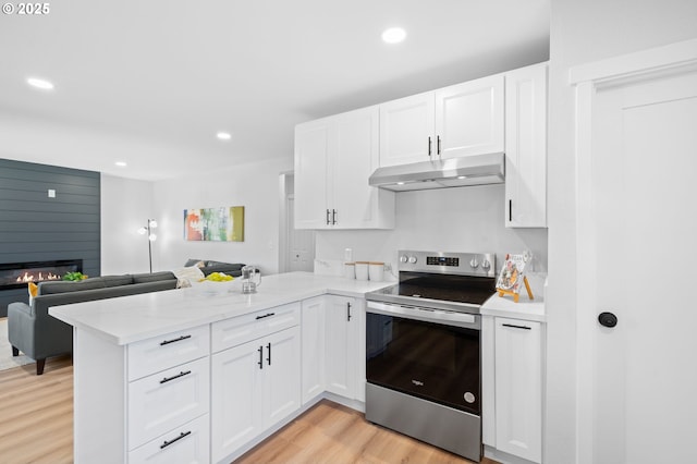 kitchen featuring a peninsula, stainless steel electric stove, under cabinet range hood, light wood-style flooring, and white cabinetry