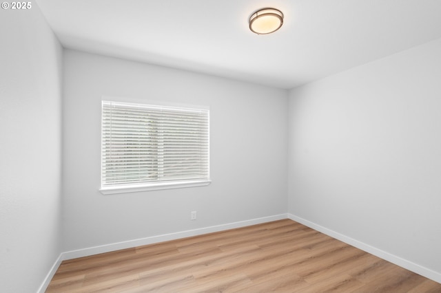 empty room with baseboards and wood finished floors