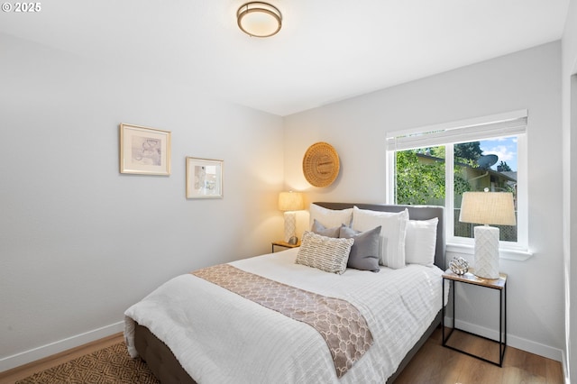 bedroom with baseboards and wood finished floors