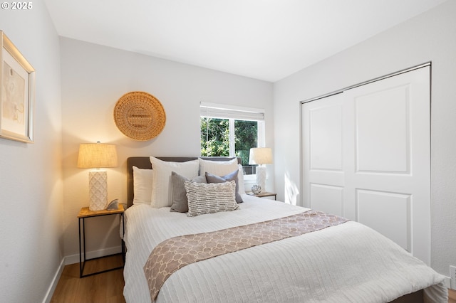 bedroom with baseboards, a closet, and wood finished floors