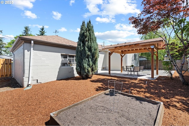 exterior space featuring fence, a patio, and a shingled roof