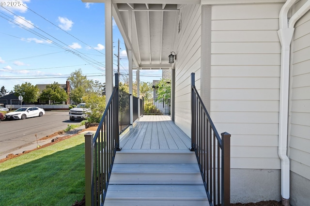wooden deck featuring covered porch and a yard
