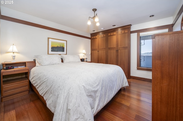 1 3rd St Unit 501, Astoria, OR 97103 - bedroom with dark wood-type flooring, a chandelier, and baseboards
