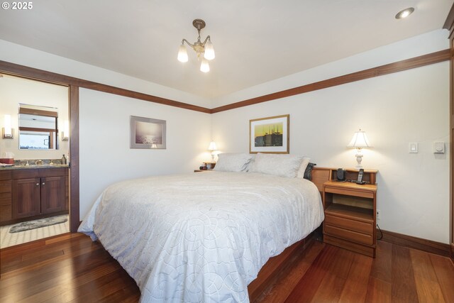 1 3rd St Unit 501, Astoria, OR 97103 - bedroom with dark wood-style flooring, baseboards, a chandelier, and ensuite bath