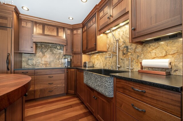 1 3rd St Unit 501, Astoria, OR 97103 - kitchen with decorative backsplash, light wood-style floors, a sink, brown cabinetry, and recessed lighting