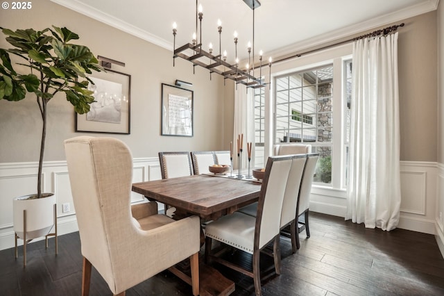 dining room with a decorative wall, crown molding, wainscoting, a chandelier, and dark wood-type flooring