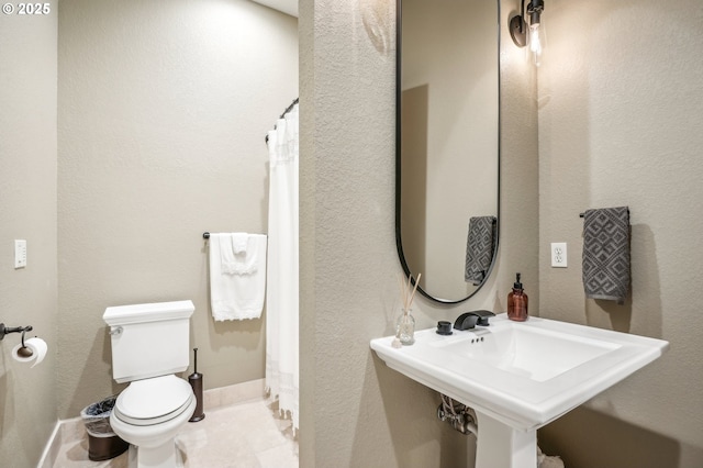 full bathroom with toilet, baseboards, a shower with shower curtain, and a sink
