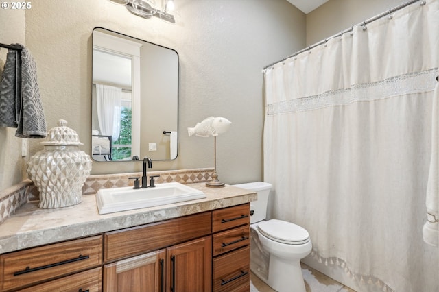 bathroom featuring vanity, toilet, a textured wall, and a shower with curtain