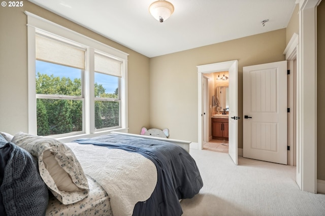 bedroom with light colored carpet and ensuite bathroom