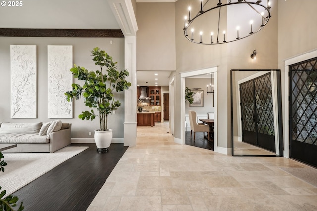 entrance foyer with a chandelier, a high ceiling, and baseboards