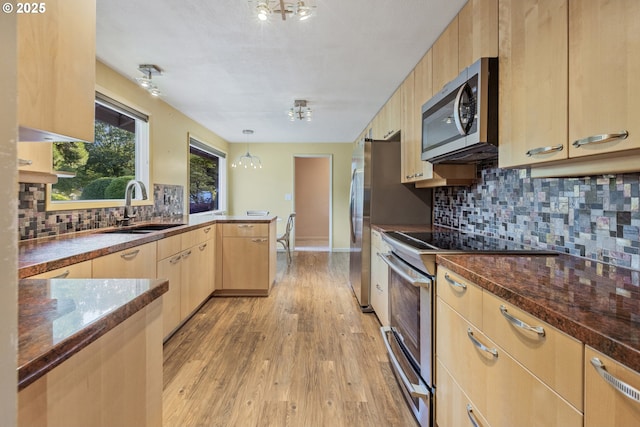2691 Country Ln, Eugene, OR 97401 - kitchen featuring stainless steel appliances, a peninsula, light brown cabinets, light wood finished floors, and decorative backsplash