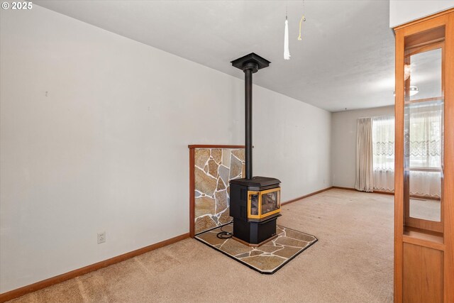 1550 Ash St, Baker City, OR 97814 - unfurnished living room with carpet, a wood stove, and baseboards