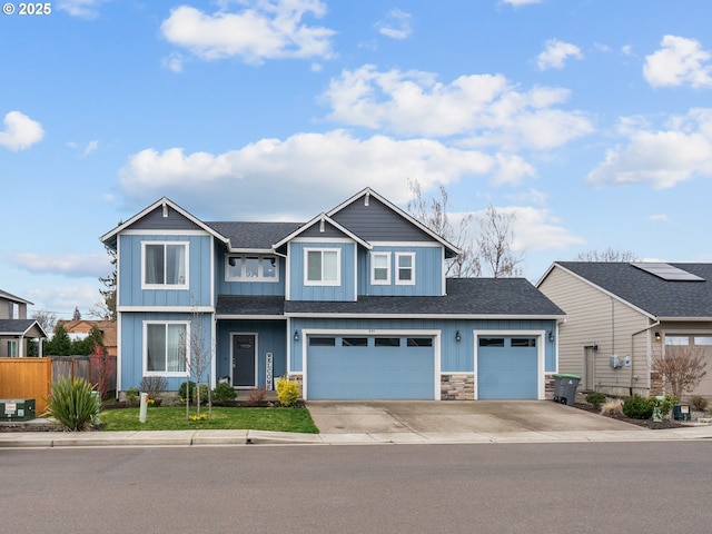 view of front facade featuring an attached garage, board and batten siding, fence, stone siding, and driveway