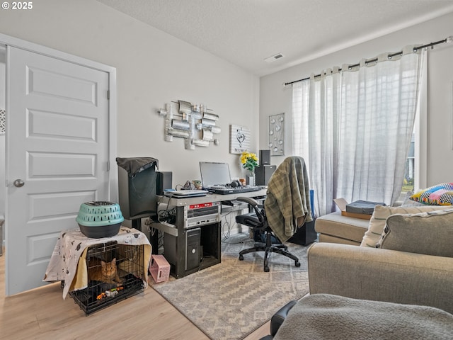 office area featuring visible vents, a textured ceiling, and wood finished floors