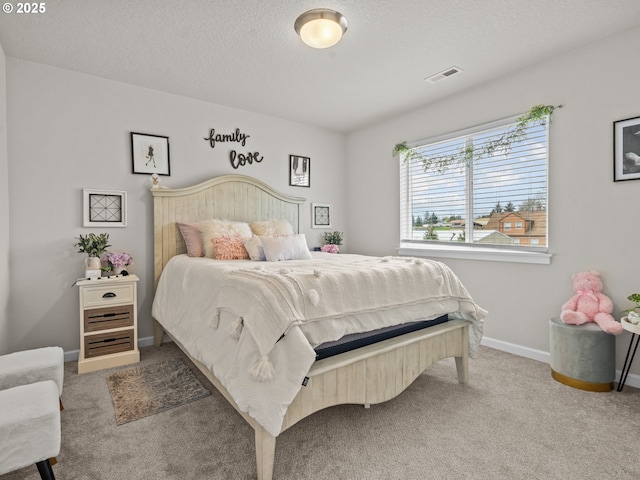 carpeted bedroom with visible vents, a textured ceiling, and baseboards