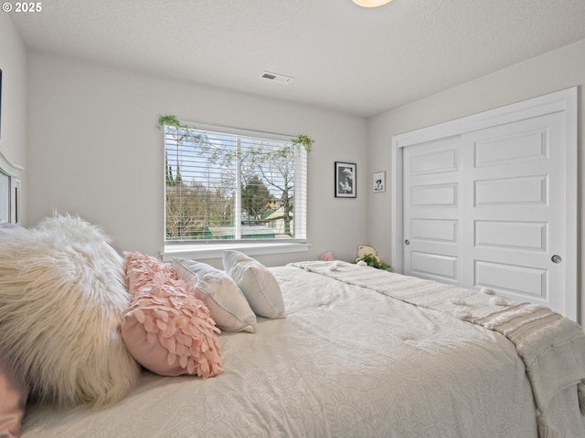 bedroom featuring visible vents and a closet