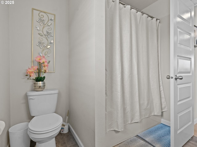 full bathroom with toilet and baseboards