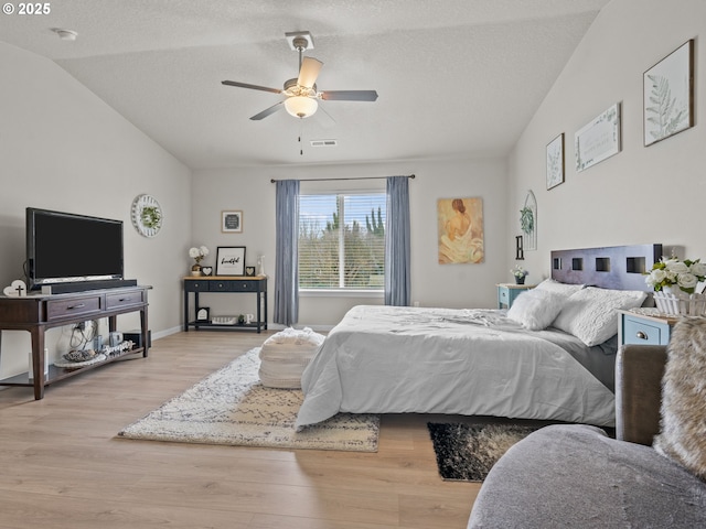 bedroom with visible vents, lofted ceiling, a textured ceiling, and wood finished floors