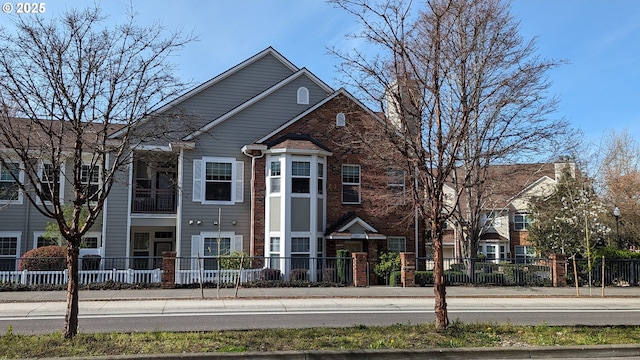 view of front of property with a fenced front yard and brick siding