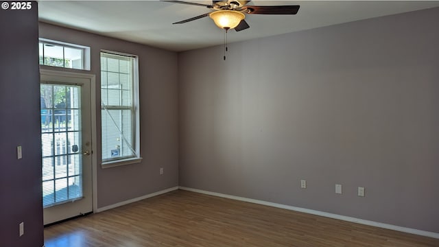 unfurnished room with baseboards, a ceiling fan, and wood finished floors