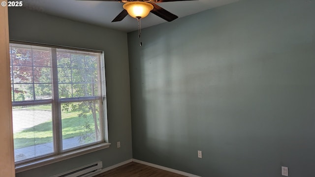 empty room with a ceiling fan, baseboards, a baseboard heating unit, and dark wood-style floors