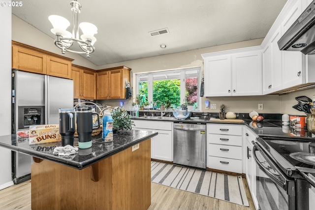 731 SE Forest Glen Rd, Estacada, OR 97023 - kitchen with appliances with stainless steel finishes, wall chimney range hood, a sink, a center island, and light wood finished floors