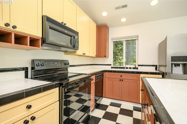 865 SE Roberts Ct, Mcminnville, OR 97128 - kitchen featuring visible vents, light floors, tile countertops, a sink, and black appliances