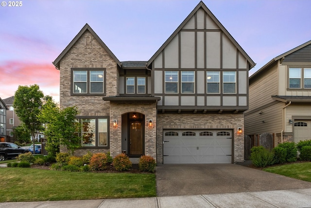 16943 SW Snowdale St, Beaverton, OR 97007 - tudor-style house featuring brick siding, driveway, an attached garage, and a front lawn
