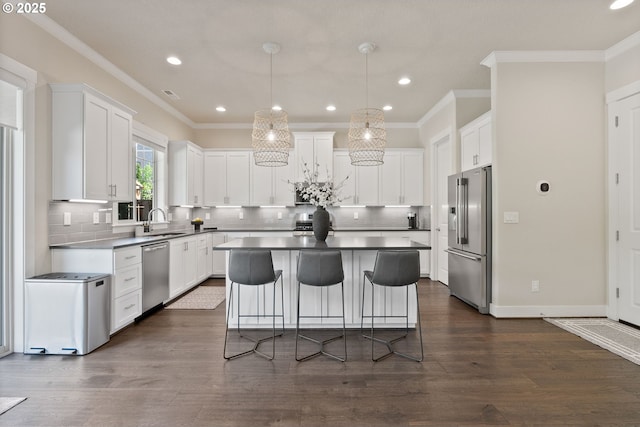 16943 SW Snowdale St, Beaverton, OR 97007 - kitchen featuring stainless steel appliances, a sink, a kitchen island, white cabinetry, and ornamental molding