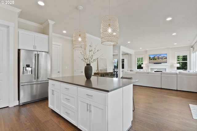 16943 SW Snowdale St, Beaverton, OR 97007 - kitchen featuring high quality fridge, crown molding, dark countertops, dark wood-type flooring, and a center island