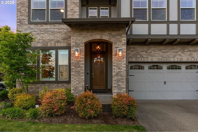 16943 SW Snowdale St, Beaverton, OR 97007 - property entrance featuring driveway, a garage, and brick siding