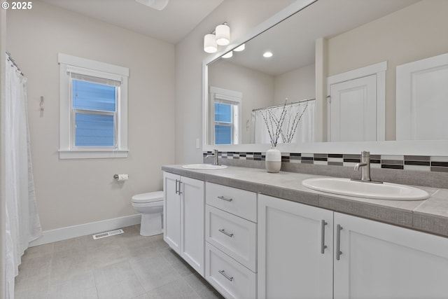 16943 SW Snowdale St, Beaverton, OR 97007 - bathroom featuring baseboards, double vanity, toilet, and a shower with curtain