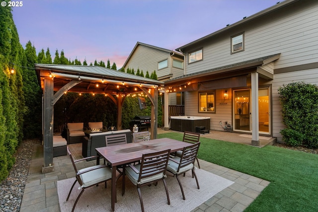 16943 SW Snowdale St, Beaverton, OR 97007 - patio terrace at dusk with a hot tub, a gazebo, a patio, a yard, and area for grilling