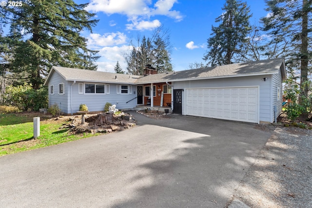 ranch-style house with aphalt driveway, an attached garage, and a chimney