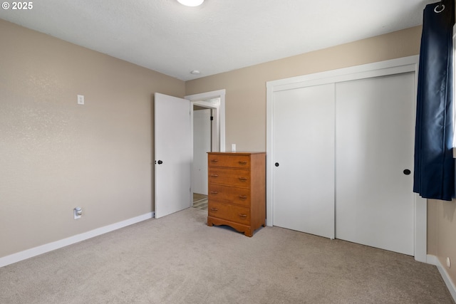 unfurnished bedroom featuring a closet, carpet flooring, and baseboards