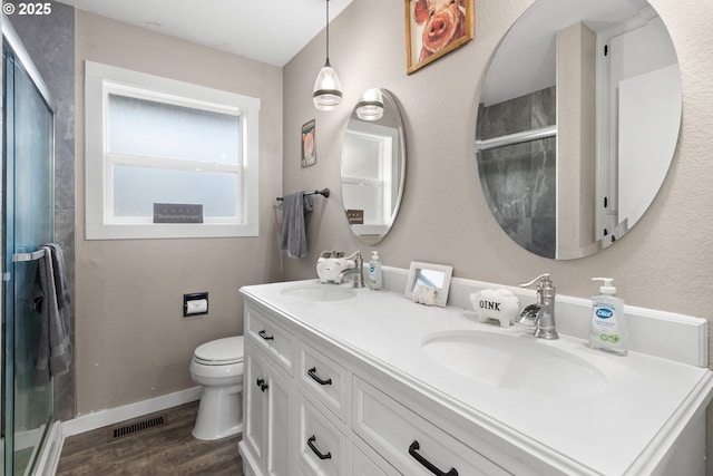 full bathroom with a sink, wood finished floors, toilet, and a stall shower