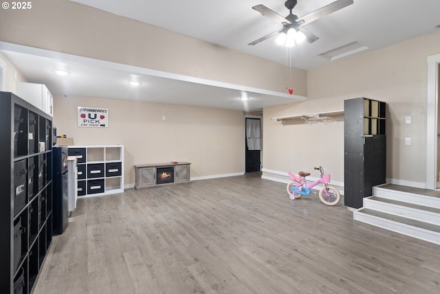 interior space featuring baseboards, ceiling fan, and light wood finished floors