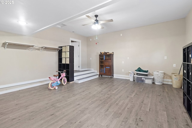 interior space with baseboards, wood finished floors, and a ceiling fan