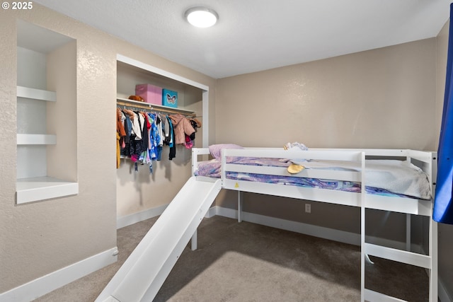 bedroom featuring baseboards, carpet, a textured wall, a closet, and a textured ceiling