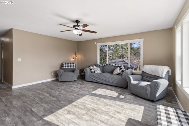 living area featuring baseboards, wood finished floors, and a ceiling fan