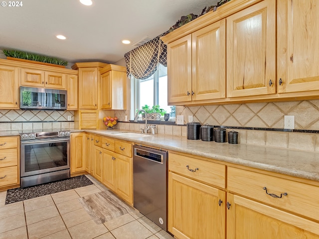 kitchen featuring decorative backsplash, light tile patterned flooring, sink, and stainless steel appliances