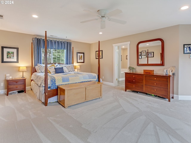 bedroom featuring ceiling fan, light carpet, and ensuite bath