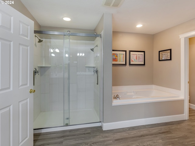 bathroom with hardwood / wood-style floors and separate shower and tub