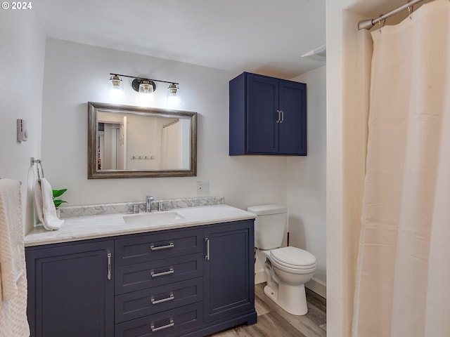 bathroom with hardwood / wood-style floors, vanity, and toilet