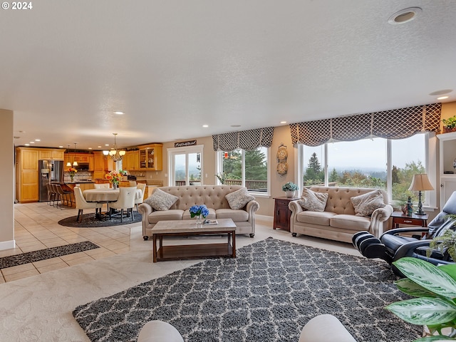 living room featuring light tile patterned floors, a textured ceiling, and a chandelier