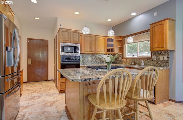 13107 SE 26th St, Vancouver, WA 98683 - kitchen featuring appliances with stainless steel finishes, backsplash, a kitchen bar, a sink, and pendant lighting