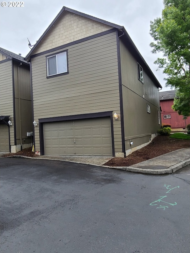 667 SE 5th Ave, Hillsboro, OR 97123 - view of property exterior featuring a garage and asphalt driveway