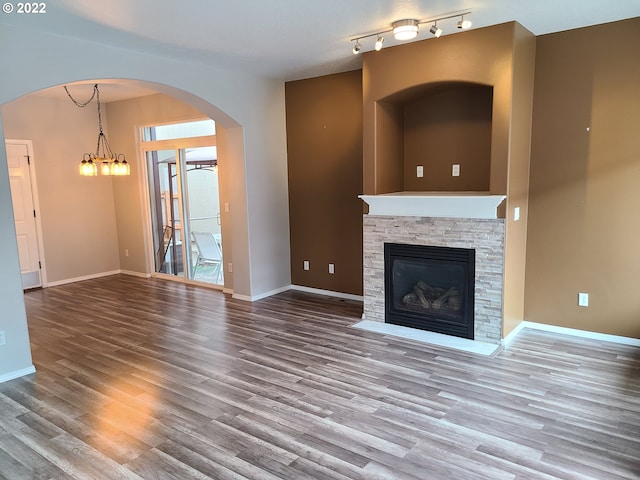 667 SE 5th Ave, Hillsboro, OR 97123 - unfurnished living room featuring wood finished floors, a fireplace, and a chandelier