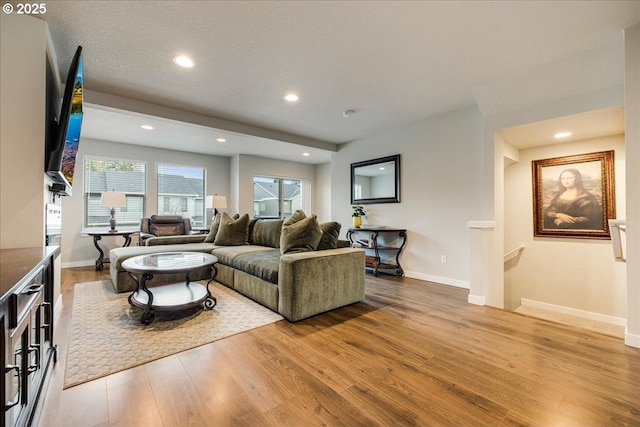 living room featuring light wood-type flooring, baseboards, and recessed lighting